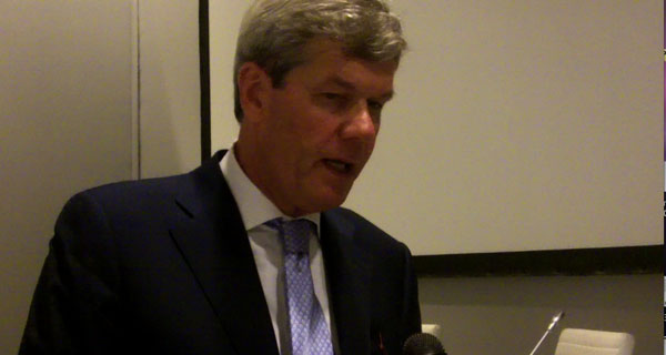 Dick Boer, esperto retail, parla di futuro. Ritratto di Boer in giacca e cravatta.