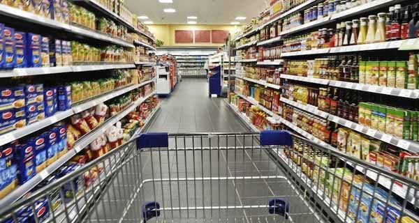 Carrello spesa pieno in supermercato. GDO, leader regionali, scaffali assortiti.