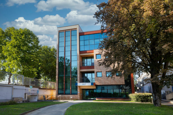 Sede CSM Ingredients: edificio moderno con vetrate e cielo azzurro. Uffici e stabilimenti alimentari.