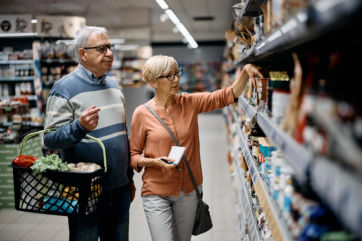 Senior couple buying groceries in supermarket.